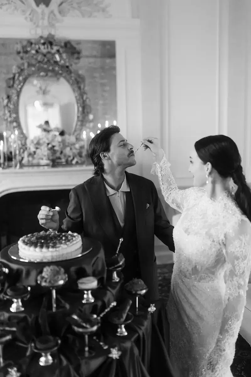 Sweet Love – emotionale Szene für Storytelling und Website-Highlights Brautpaar füttert sich gegenseitig Dessert – romantischer und verspielter Moment im Schwarz-Weiß-Stil